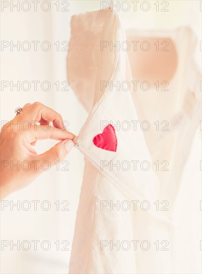 Close up of woman's hand holding wedding dress