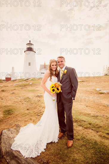 Portrait of married couple, lighthouse in background