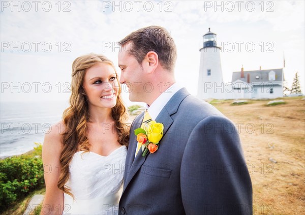 Portrait of married couple, lighthouse in background