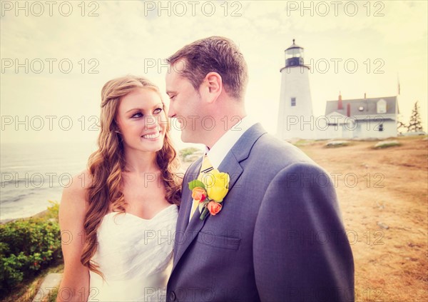 Portrait of married couple, lighthouse in background