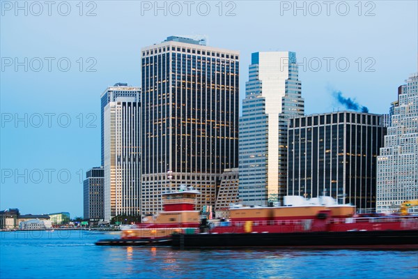 Cityscape at dusk, boats on river