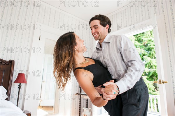 Young couple dancing in bedroom