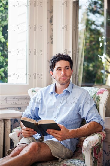 Portrait of young man relaxing with book