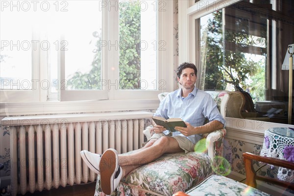 Portrait of young man relaxing with book