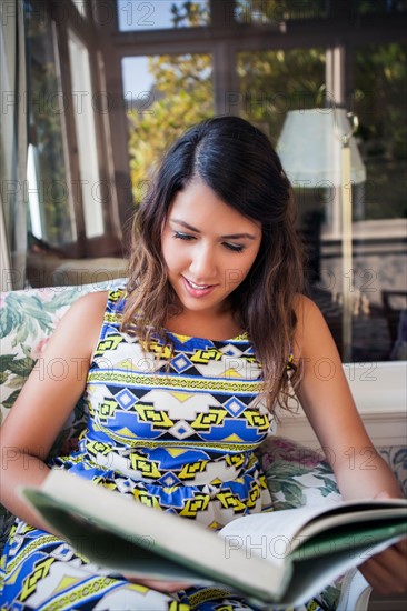 Portrait of young woman reading book