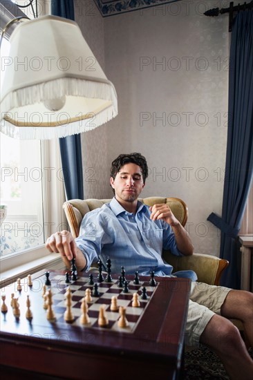 Portrait of young man playing chess