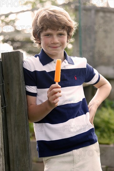 Boy (12-13) standing and eating ice cream