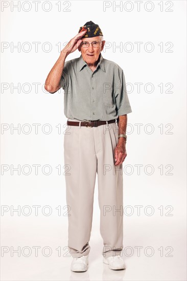 Portrait of senior man standing and saluting at camera