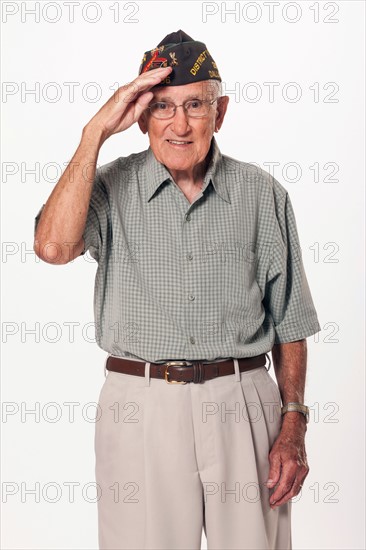 Portrait of senior man standing and saluting at camera