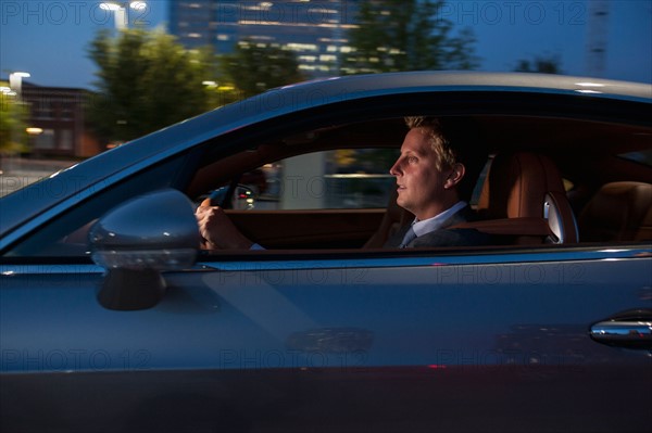 Profile of businessman driving car