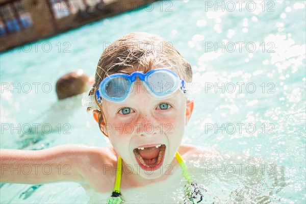 Girl and boy (4-5) playing in swimming pool