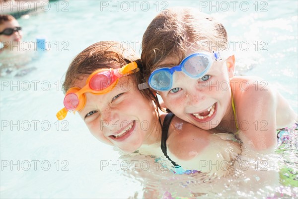 Girlfriends (4-5, 8-9) playing in swimming pool