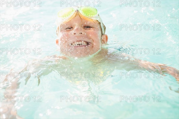 Boy (4-5) swimming in swimming pool