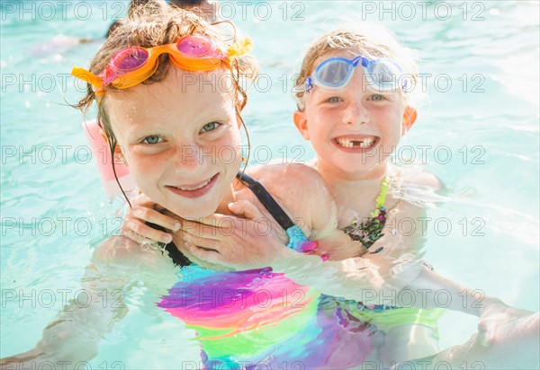 Girlfriends (4-5, 8-9) playing in swimming pool