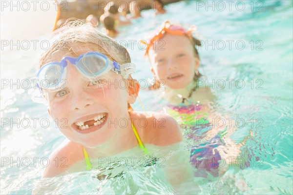 Girlfriends (4-5, 8-9) playing in swimming pool