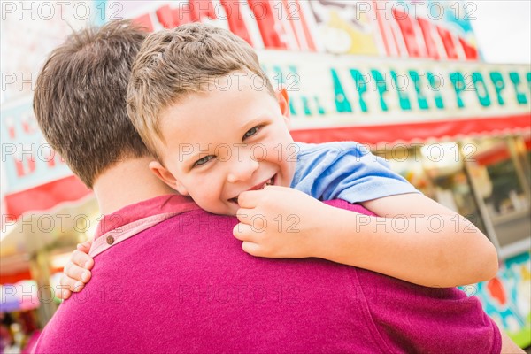 Father and son (4-5) in amusement park