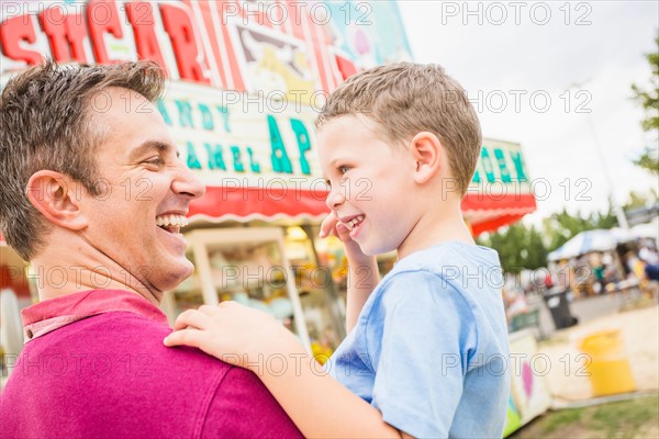 Father and son (4-5) in amusement park