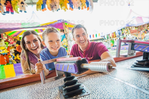 Happy Family with son (4-5) playing with water gun in amusement park