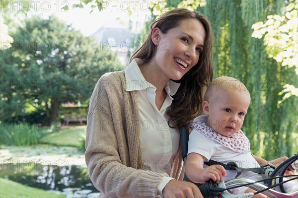 Mother with her baby daughter (12-17 months) on bicycle