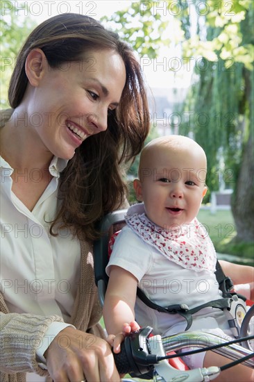 Mother with her baby daughter (12-17 months) on bicycle