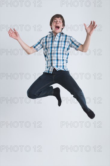 Studio Shot of teenage boy (14-15) jumping