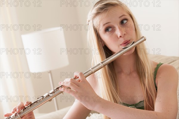 Girl (14-15) playing reed flute