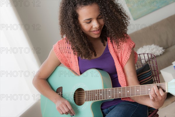 Girl (12-13) playing guitar