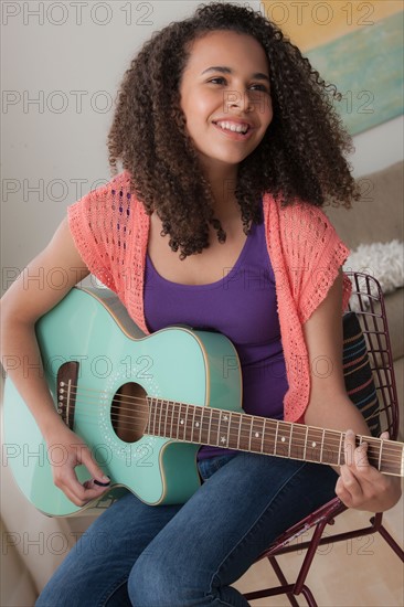 Girl (12-13) playing guitar