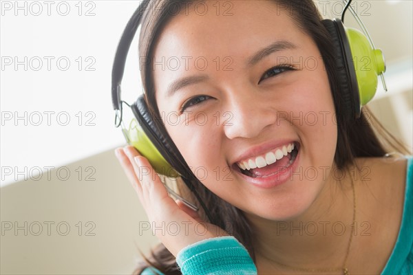 Girl (16-17) listening to music wearing headphones