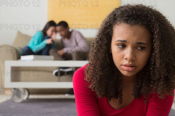 Girl (12-13) crying while two teenagers (14-15,16-17) whispering behind her