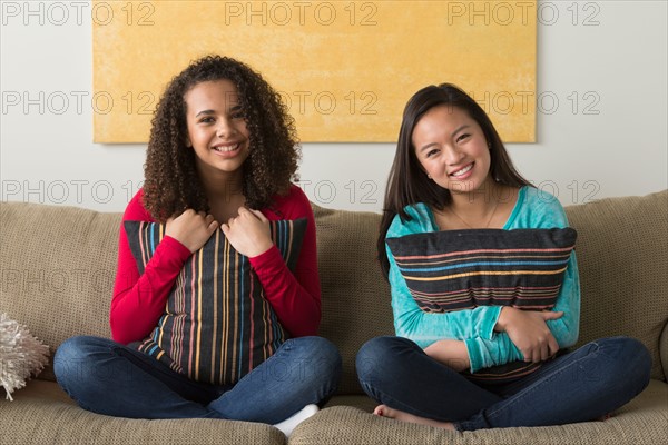 Two friends (12-13,16-17) sitting on sofa