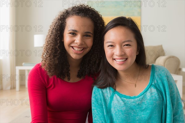 Two friends (12-13,16-17) sitting on sofa