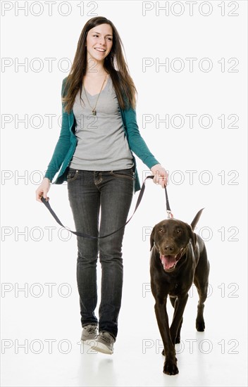 Studio shot of young woman with chocolate labrador