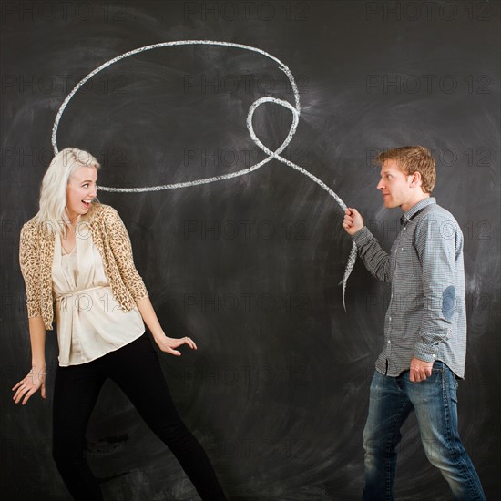 Studio portrait of young couple with chalk lasso