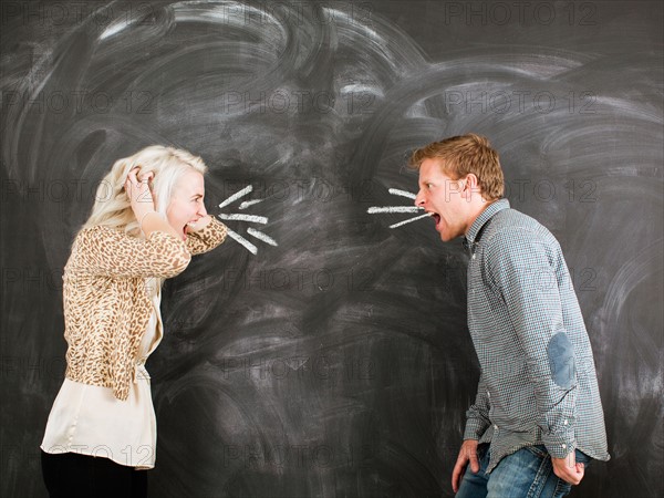 Studio portrait of young couple shouting at each other