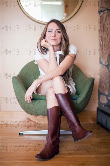 Portrait of young woman sitting on armchair