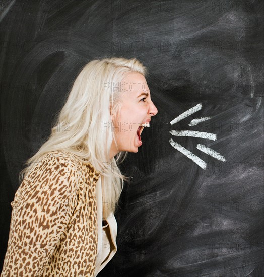 Studio portrait of young woman shouting