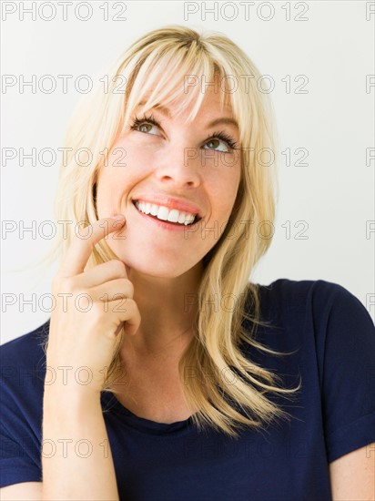 Studio portrait of blonde woman looking up