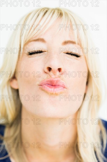 Studio portrait of blonde woman puckering