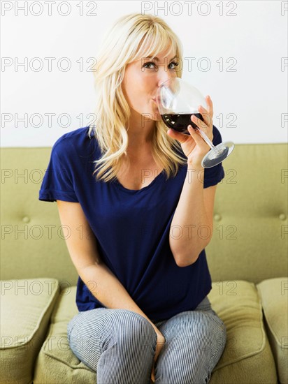 Woman relaxing on sofa and drinking wine