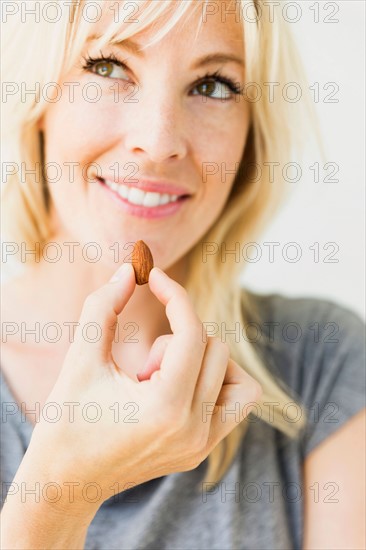 Woman eating candy cane, studio shot