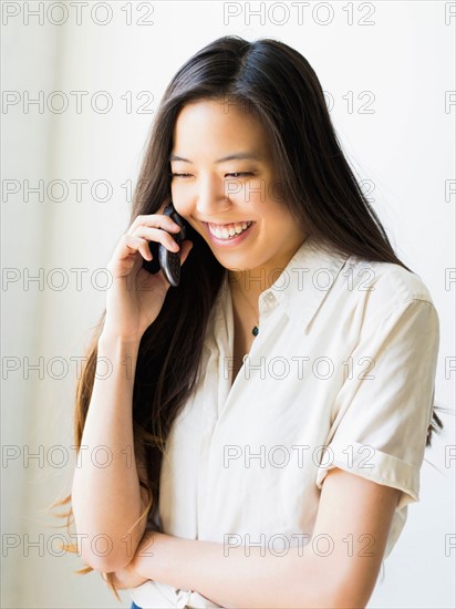 Smiling young woman talking via mobile phone