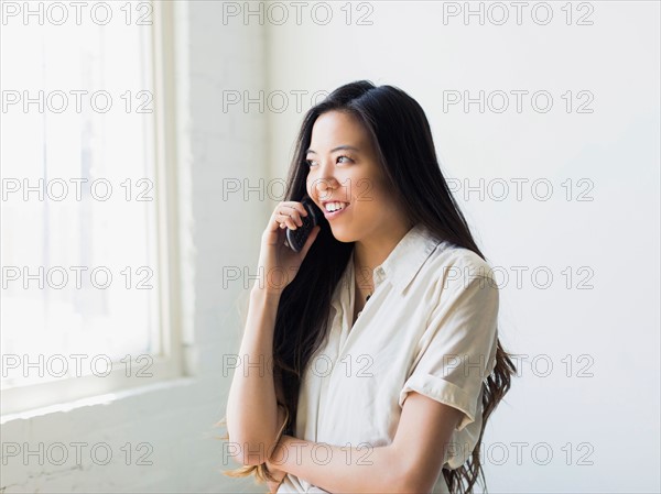 Smiling young woman talking via mobile phone