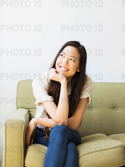 Happy young woman sitting on sofa