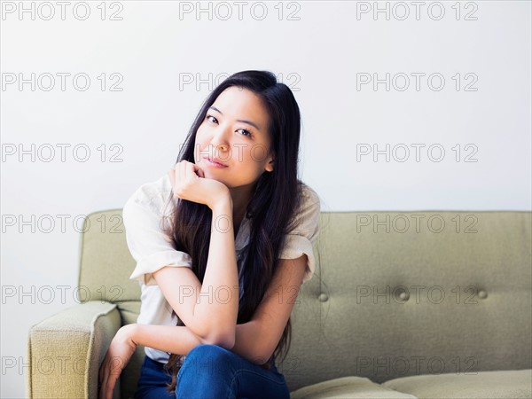 Young woman sitting on sofa