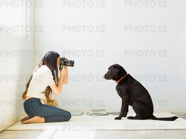 Woman photographing dog in studio