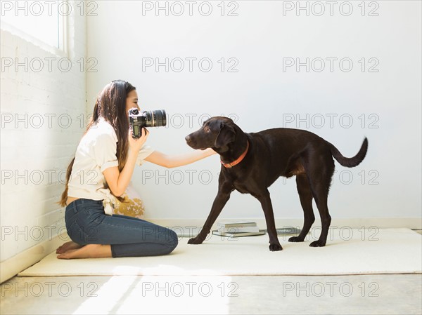 Woman photographing dog in studio