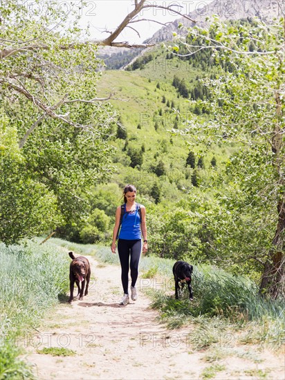 Woman with two dogs hiking in landscape