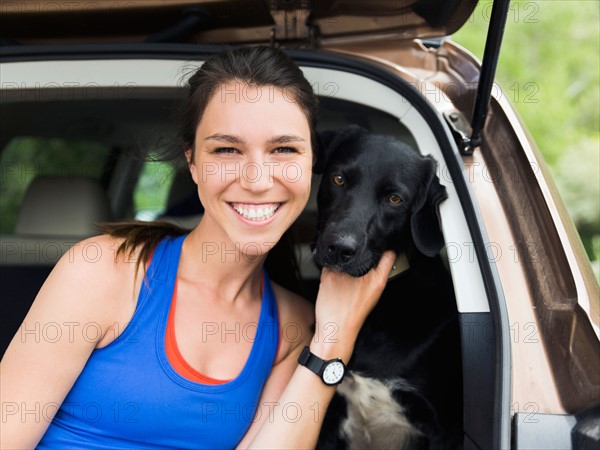 Woman sitting in car with dog