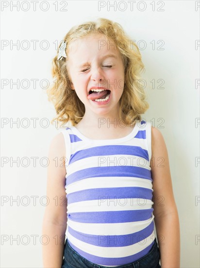 Portrait of blonde girl (4-5) sticking out tongue